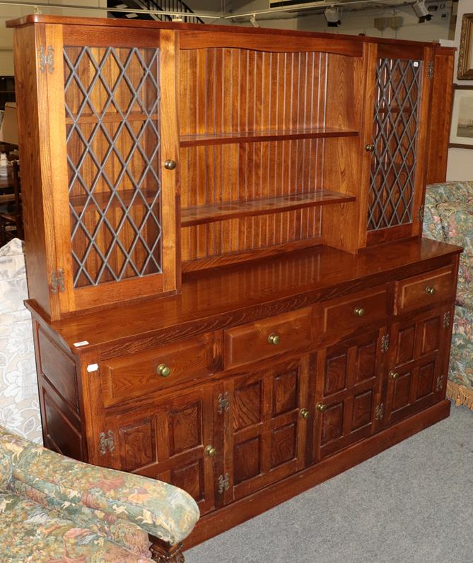 Lot 1068 - A modern oak dresser, the upper section with shelves and lead glazed doors, the lower section...