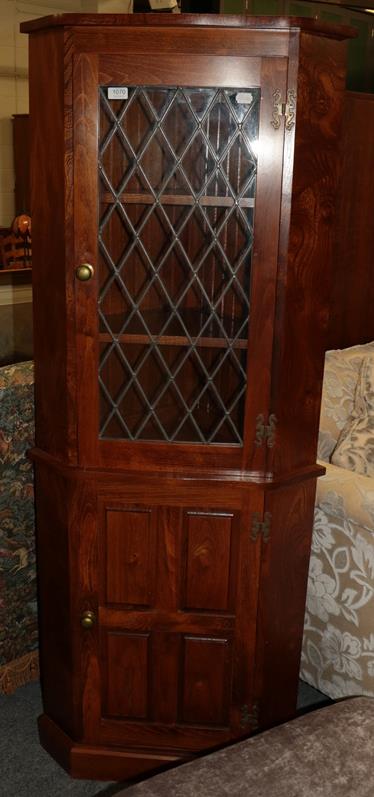 Lot 1070 - A modern oak standing corner cupboard with lead glazed upper section and panelled lower...