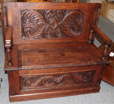 Lot 1076 - A 20th century carved oak monks bench, 104cm by 47cm by 90cm
