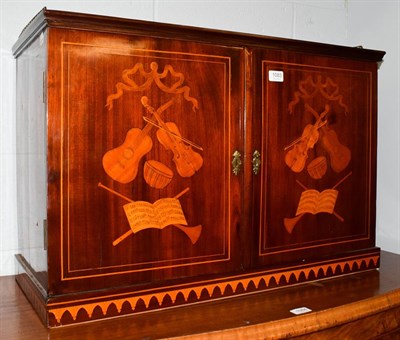 Lot 1083 - A 19th century Dutch mahogany and marquetry inlaid double door cabinet, inlaid overall with musical