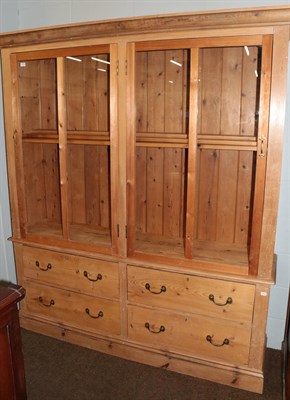 Lot 1099 - A pine farmhouse kitchen dresser with two large glazed doors, over a base section fitted with...