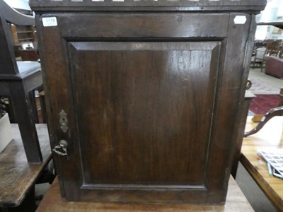 Lot 1118 - An 18th century panelled oak hanging wall cupboard, 63cm by 23cm by 73cm