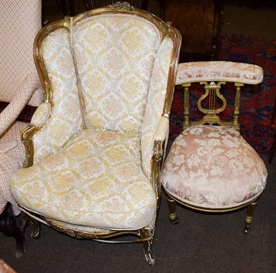 Lot 1140 - A Louis XV style gilt fauteuil, together with a Louis XVI style gilt music chair with lyre form...