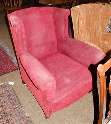 Lot 1144 - An early 20th century mahogany framed, deep seated, red upholstered wing back arm chair, moving...