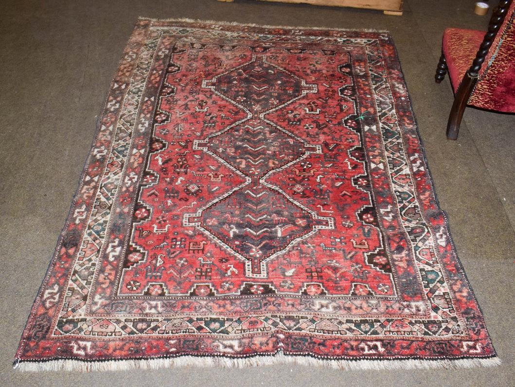 Lot 1157 - Kashgai rug, the faded raspberry field of tribal and zoomorphic devices around three stepped...