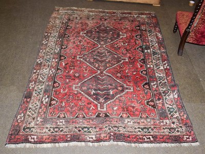 Lot 1157 - Kashgai rug, the faded raspberry field of tribal and zoomorphic devices around three stepped...