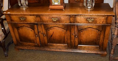 Lot 1171 - An oak panelled three drawer and three door dresser base, 158cm by 46cm by 80cm.