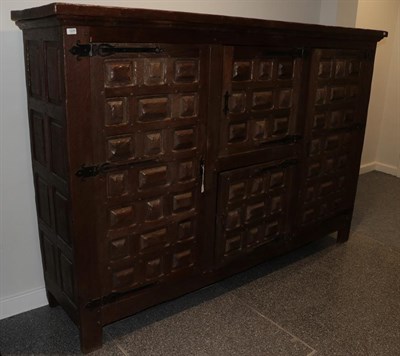 Lot 1229 - A large Arts & Crafts oak linen cupboard, adzed all over, with a rectangular top over two...