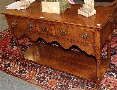 Lot 1251 - An oak dresser base fitted with three drawers and a pot board, 118cm by 40cm by 77cm