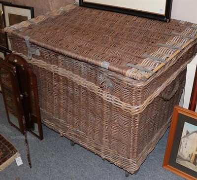 Lot 1254 - An early 20th century wicker basket, with hinged lid and metal bindings, rope side carrying...