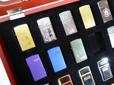 Lot 8 - ~ Three collectors display cases containing a total of fifty-seven Zippo lighters, a rotating...
