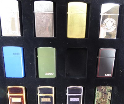 Lot 8 - ~ Three collectors display cases containing a total of fifty-seven Zippo lighters, a rotating...