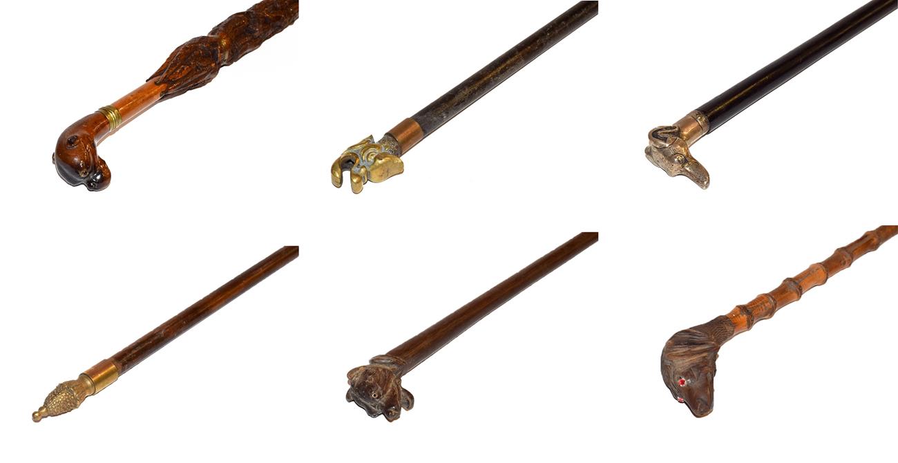 Lot 26 - ~ Four novelty walking canes, one carved in the form of an umbrella and each with a topper in...