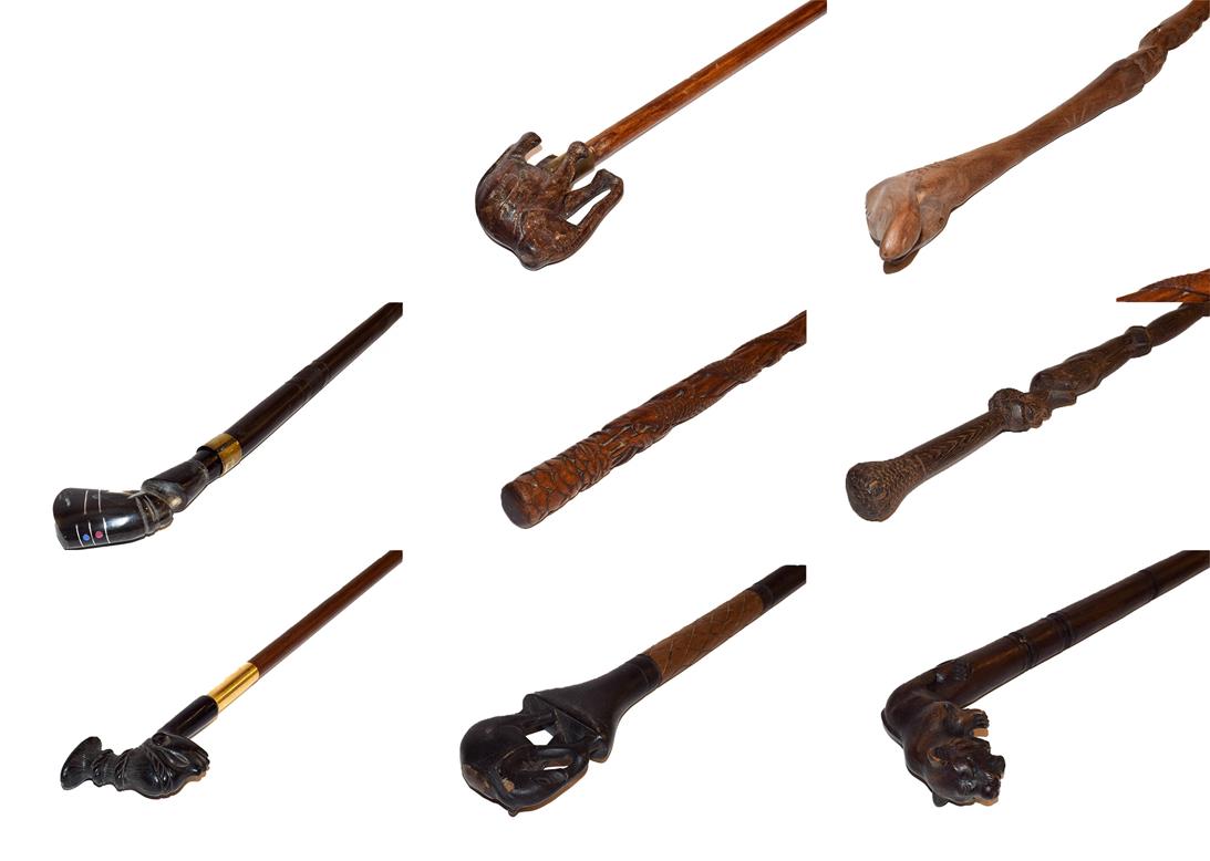 Lot 27 - ~ A collection of carved walking sticks including African hardwood examples with figural and...