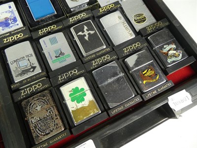 Lot 45 - ~ A collection of Zippo lighters including advertising and leather mounted examples (2 trays)