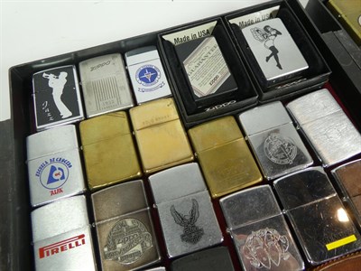Lot 45 - ~ A collection of Zippo lighters including advertising and leather mounted examples (2 trays)