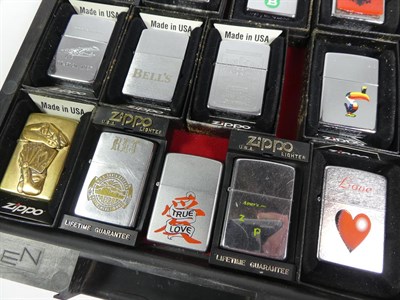 Lot 49 - ~ A collection of Zippo lighters including advertising and brass examples (3 trays)
