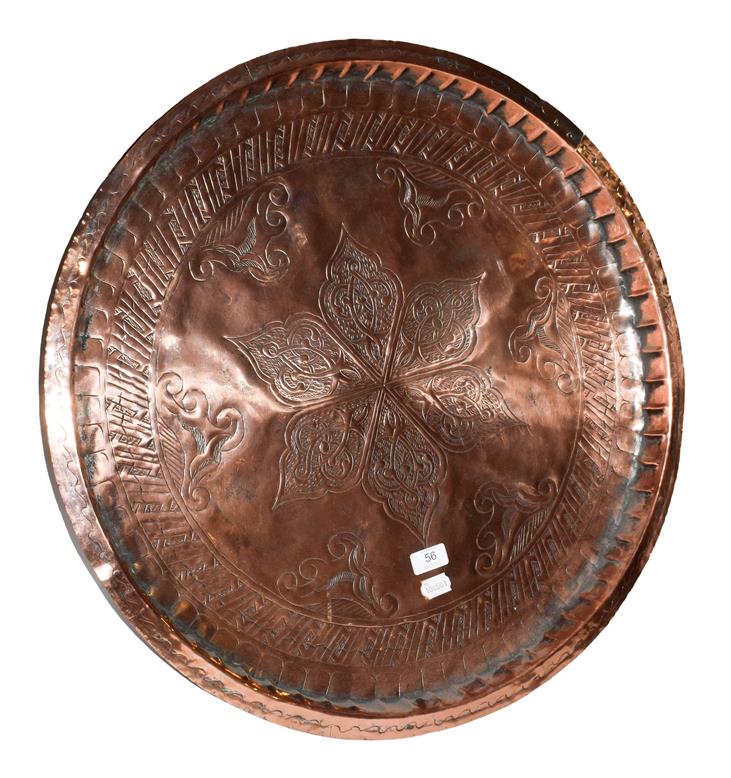 Lot 56 - ~ A 19th century Continental copper serving tray with repoussé decoration, 85cm diamater