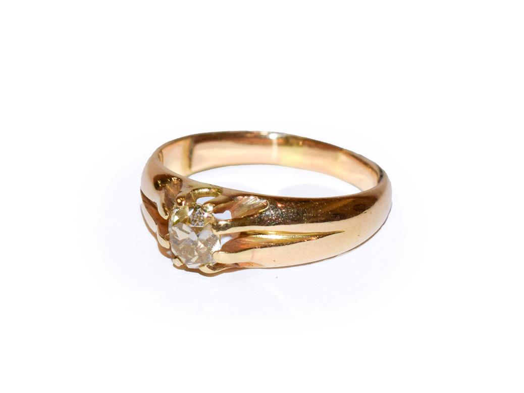 Lot 103 - ~ A diamond solitaire ring, the old cut diamond in a yellow claw setting, to a plain polished...