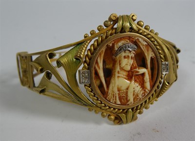 Lot 106 - ~ An Art Nouveau style gilt hinged bangle decorated with a lady in profile with rose cut...