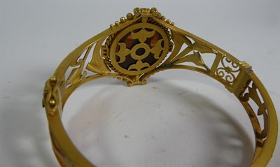 Lot 106 - ~ An Art Nouveau style gilt hinged bangle decorated with a lady in profile with rose cut...