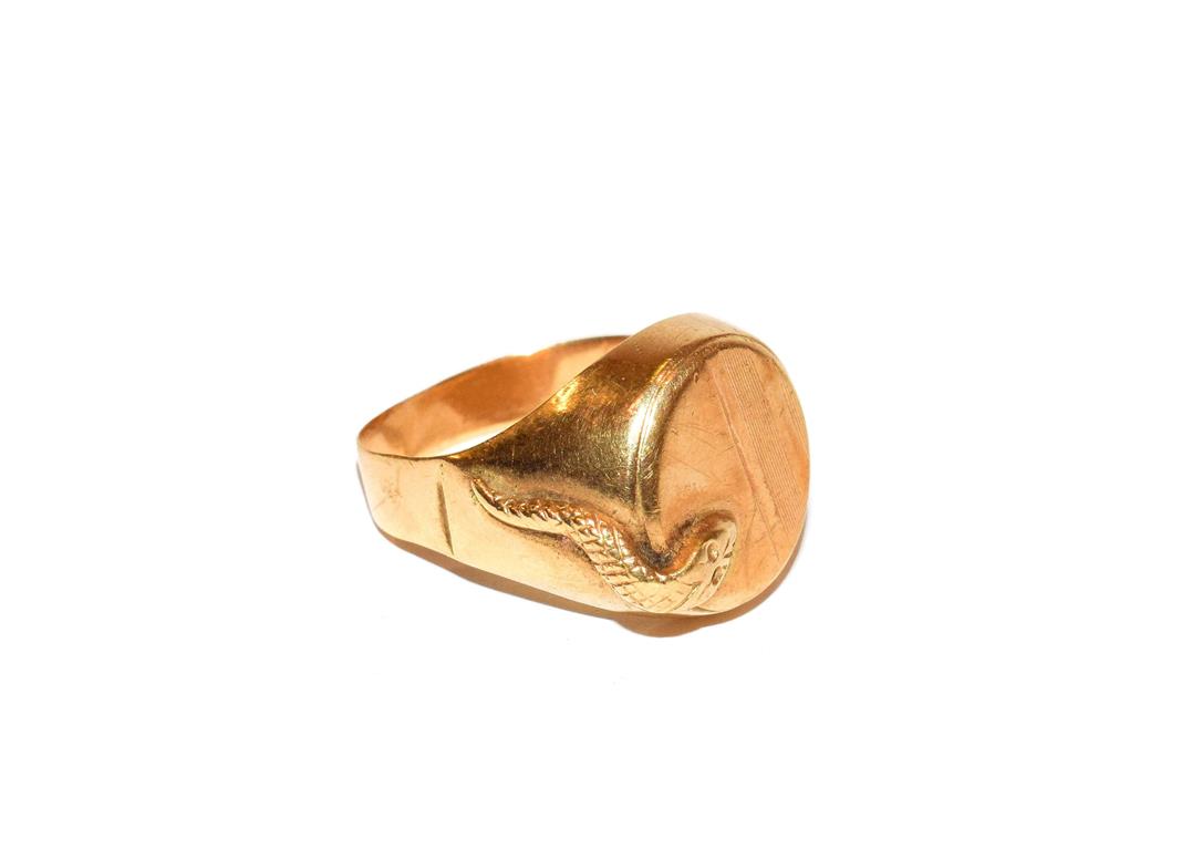 Lot 109 - ~ A signet ring, the circular shield with a snake motif to one side, stamped '750' (a.f.)