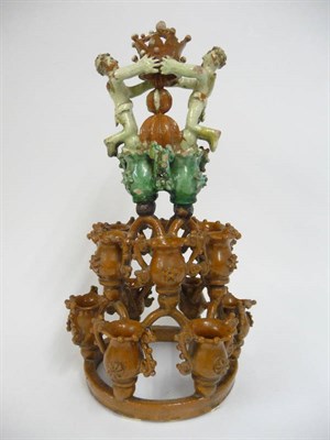 Lot 127 - A Central European Slipware Centrepiece, 18th/19th century, as two figures supporting a crown on an