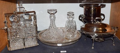 Lot 247 - A silver plated two bottle tantalus, three other decanters including a ships decanter on...
