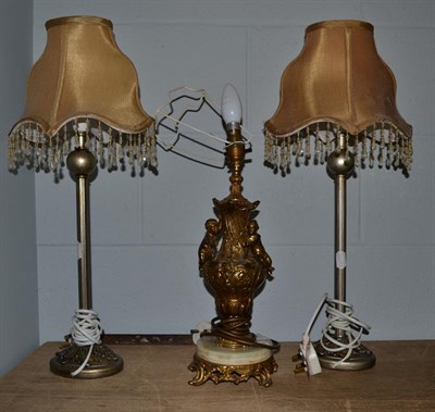 Lot 398 - A pair of modern silvered table lamps together with a gilt metal and onyx table lamp of urn...