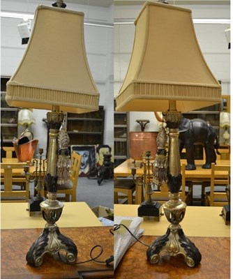 Lot 424 - A pair of modern silvered and bronzed composite table lamps, each of column form on triform...