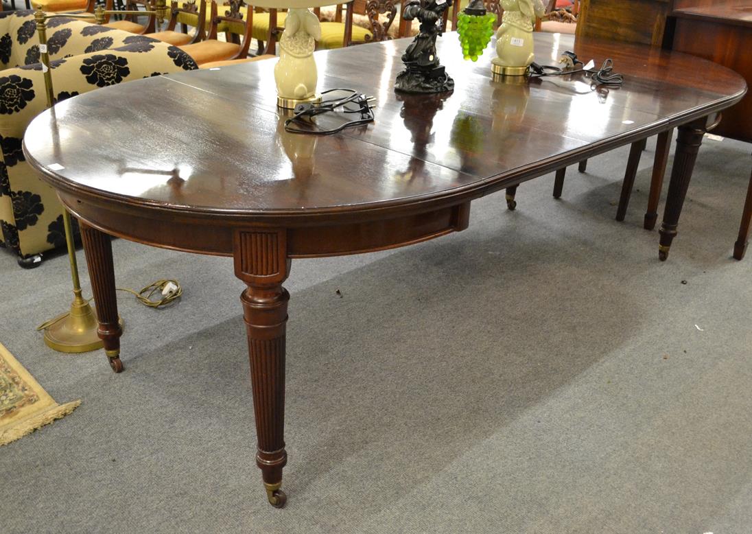 Lot 1099 - A mahogany wind out dining table raised on tapering reeded legs with three additional leaves, 240cm