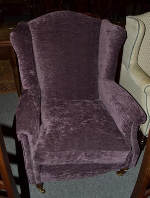 Lot 1104 - A purple upholstered wing armchair in the Georgian style