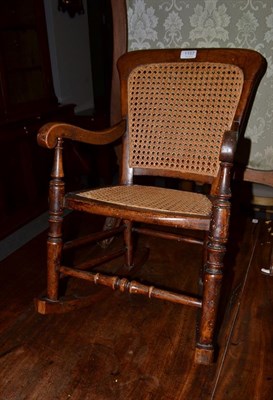 Lot 1157 - A 19th century elm cane childs rocking chair