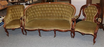Lot 1218 - A Victorian mahogany framed sofa upholstered in buttoned green fabric and two similar armchairs (3)