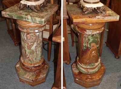 Lot 1253 - A pair of substantial onyx columns, the square tops over a circular section standard, raised on...
