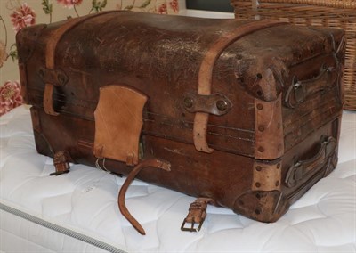 Lot 1315 - A 19th century brown leather trunk, hinged and enclosing a blue and white striped cotton lining...