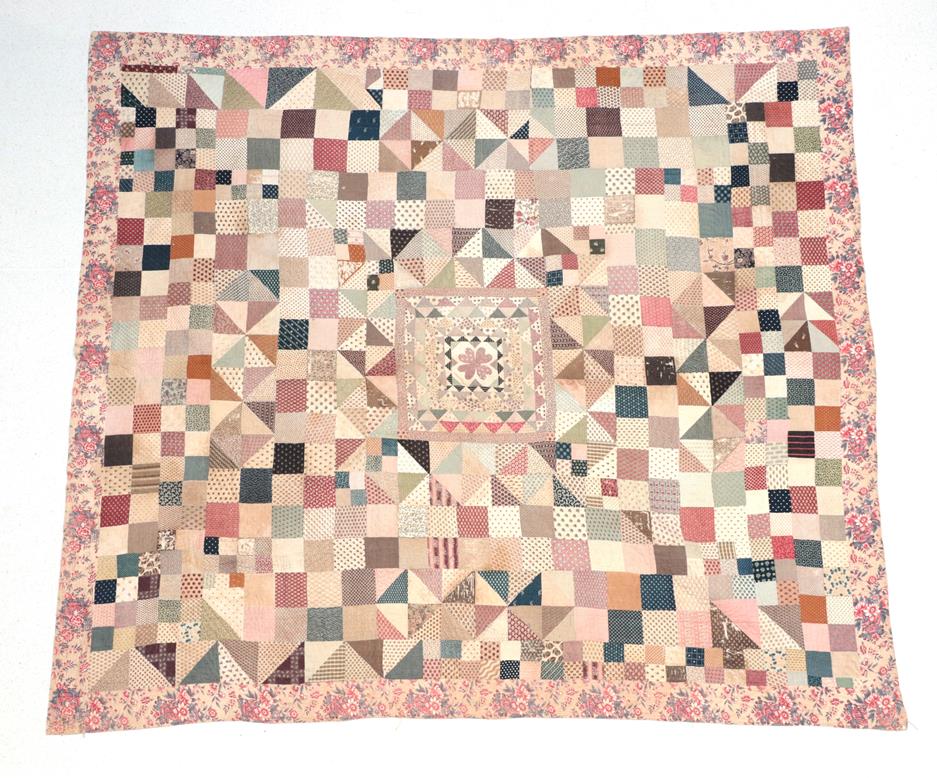 Lot 2021 - A Large 19th Century Patchwork Quilt, comprising a central square with small frames around a...