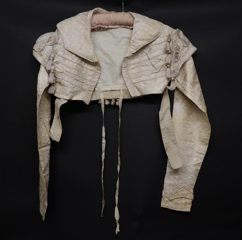 Lot 2049 - An Early 19th Century Regency Cream Figured Silk Wedding Jacket, woven with clovers, decorated with