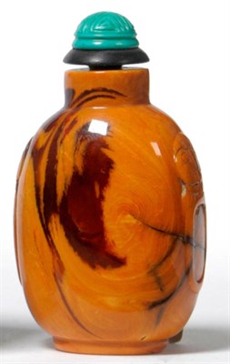 Lot 215 - A Chinese Resin Amber Snuff Bottle, Qing Dynasty, of round shouldered form with fo dog mask and...