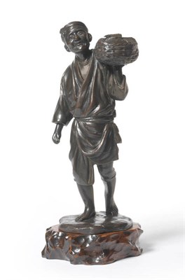 Lot 228 - A Japanese Bronze Figure of a Fisherman, Meiji period (1868-1912), walking in robes, a basket...