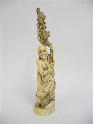 Lot 234 - A Japanese Ivory Okimono, Meiji period (1868-1912), as an old man in loose robes, two quail amongst