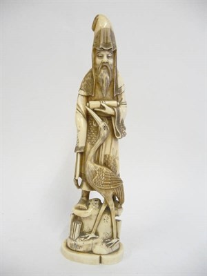 Lot 235 - A Japanese Marine Ivory Okimono, Meiji period (1868-1912), of a bearded man in flowing robes,...