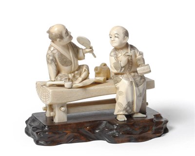 Lot 241 - A Japanese Walrus Ivory Figure Group, late Meiji period (1868-1912), as two gentlemen by a...