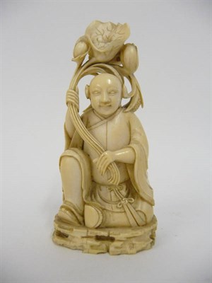 Lot 246 - A Chinese Carved Ivory Figure of a Young Man Holding Lotus, probably 18th century, enrobed and...