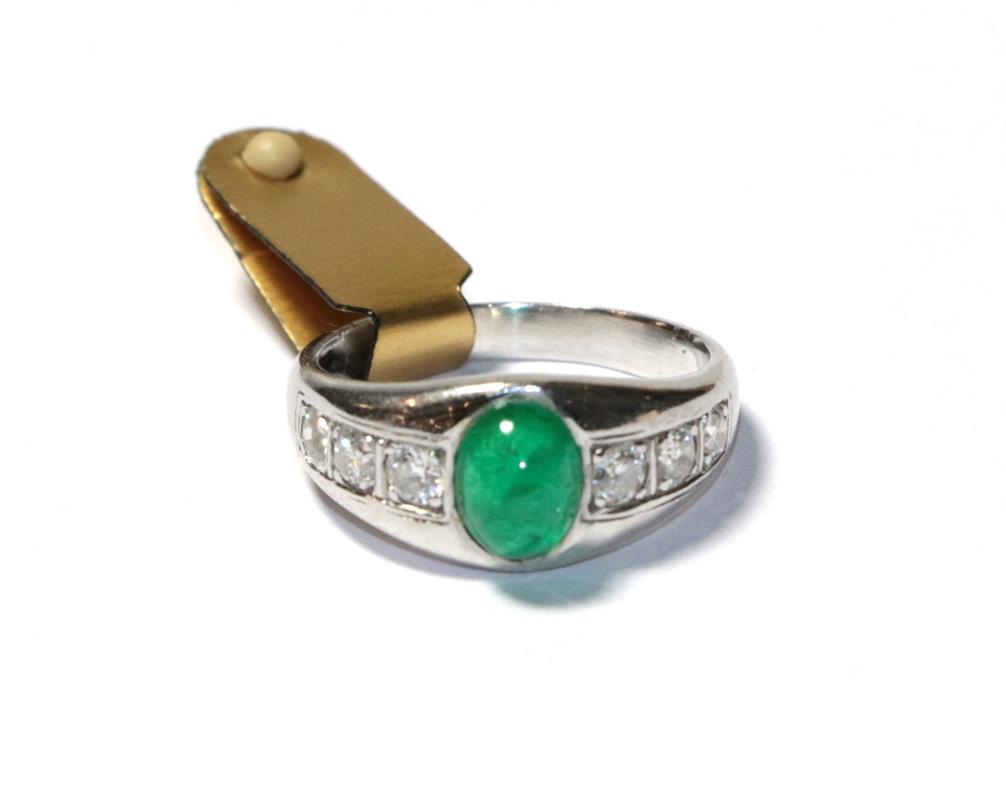 Lot 52 - An emerald and diamond ring, the cabochon emerald in a white collet setting, to shoulders inset...