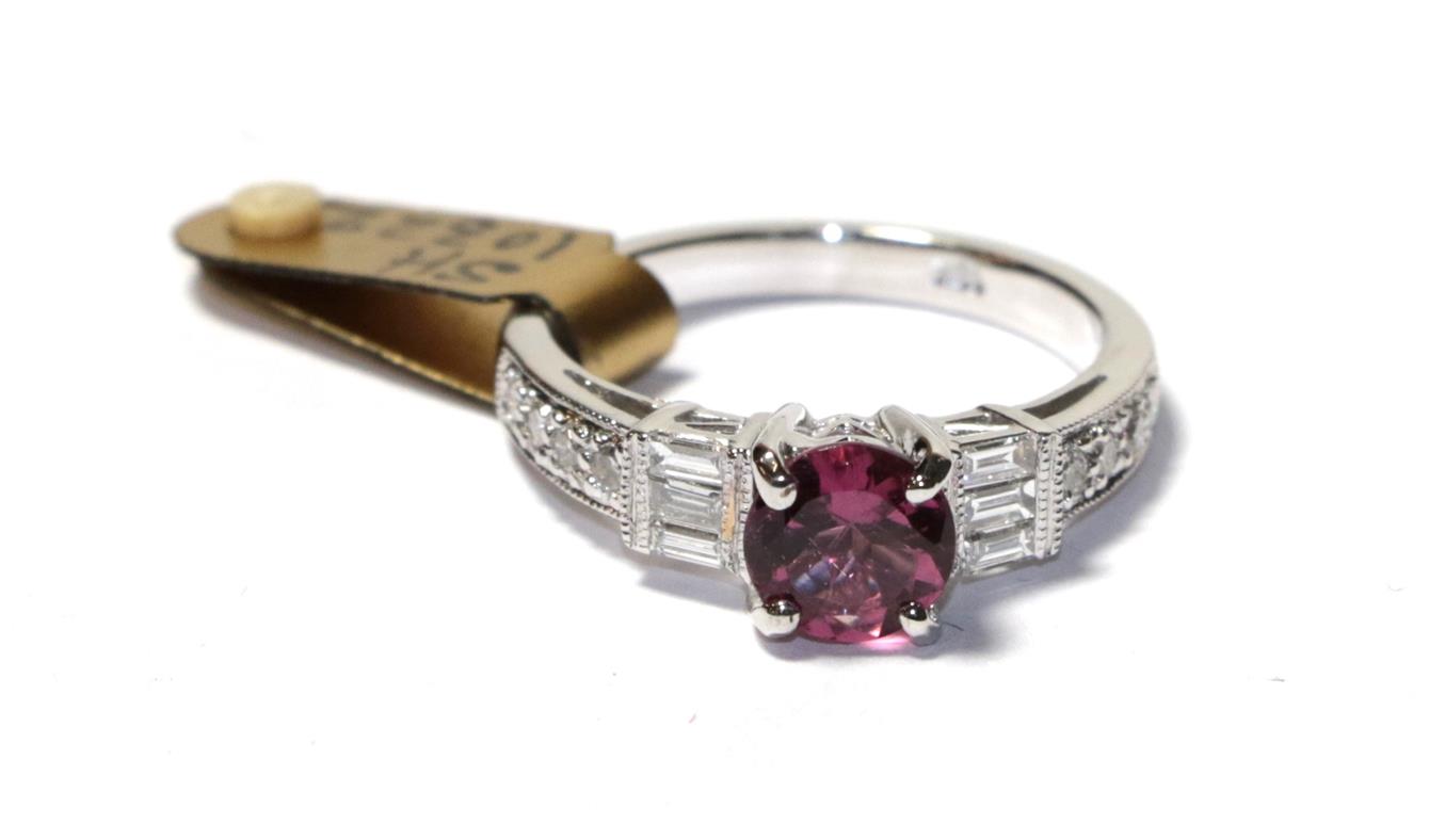 Lot 61 - A tourmaline and diamond ring, the round cut pink tourmaline flanked by trios of baguette cut...