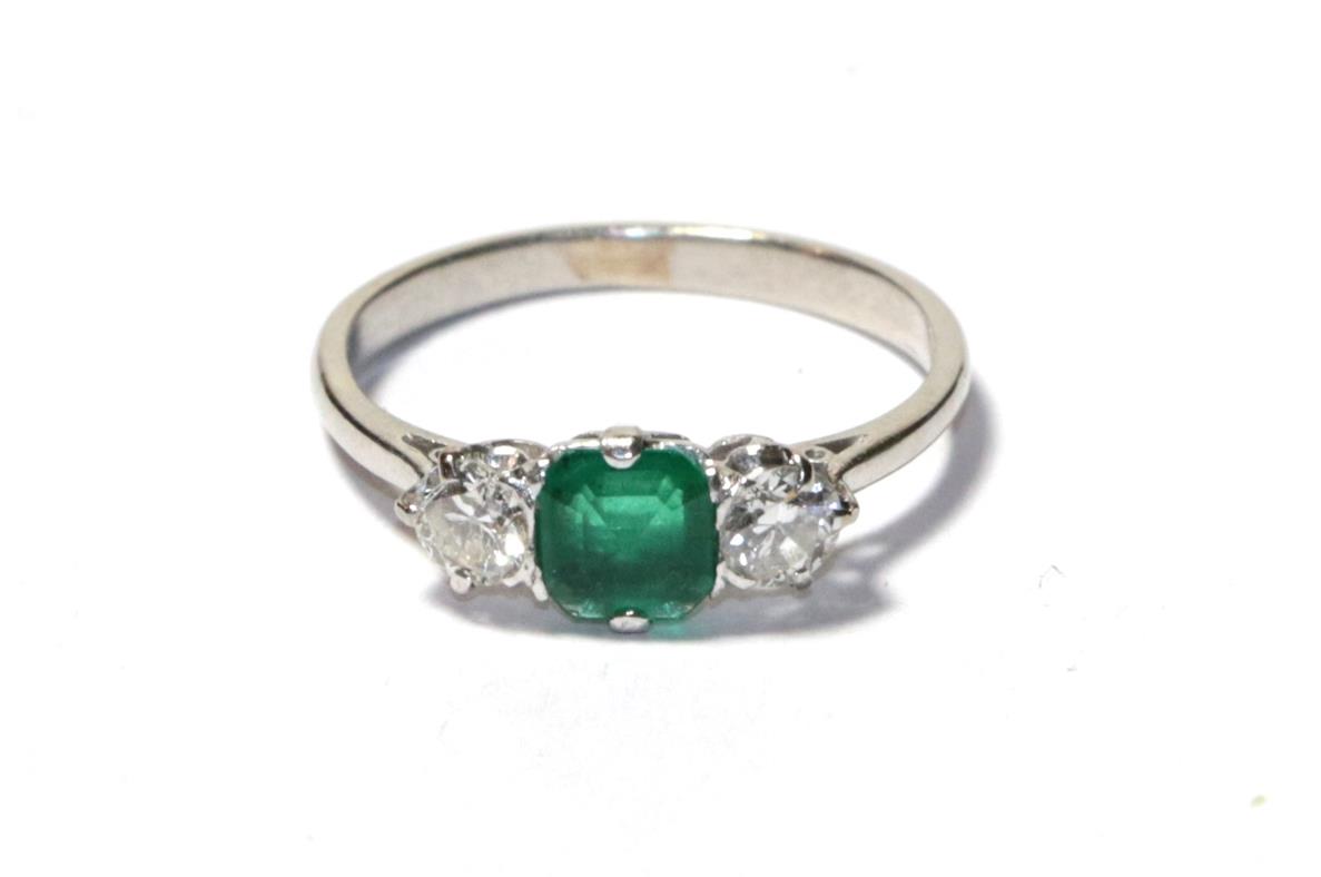 Lot 73 - An emerald and diamond three stone ring, the asscher cut emerald flanked by round brilliant cut...