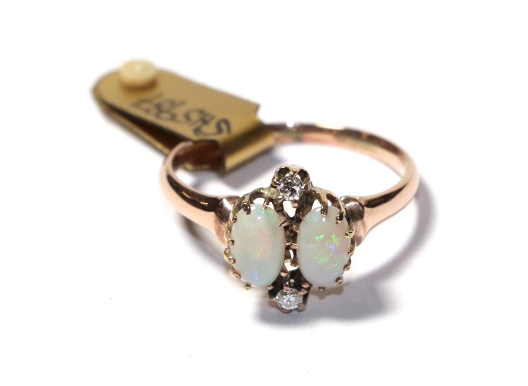 Lot 74 - An opal and diamond ring, the two oval cabochon opals with round brilliant cut diamond accents,...