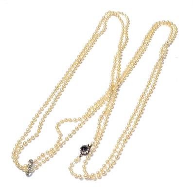 Lot 77 - A seed pearl necklace knotted to a sapphire and diamond cluster clasp with a diamond set...