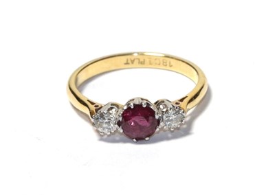Lot 88 - A ruby and diamond three stone ring, the round cut ruby flanked by round brilliant cut diamonds...